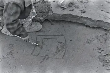  ??  ?? BELOW
Drawing a story in the sand with an ivor y stor yknife in Bethel, Alaska, 1936 COURTESY MUSEUM RIETBERG (FHH 15-14)
PHOTO HANS HIMMELHEBE­R