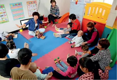  ??  ?? UNICEF’s expert Li Tong pays a regular visit to the ECD center establishe­d in a village of Hubei Province and teaches parents better ways to raise their children.