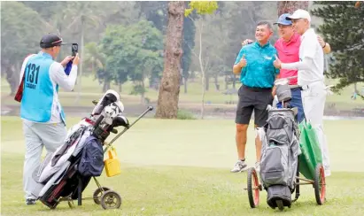  ?? PHOTOGRAPH COURTESY OF PAL ?? PLAYERS have their photos taken by a caddie during a practice round for the 75th PAL Interclub golf tournament championsh­ips at the Del Monte Golf Club in Manolo Fortich, Bukidnon on Tuesday.