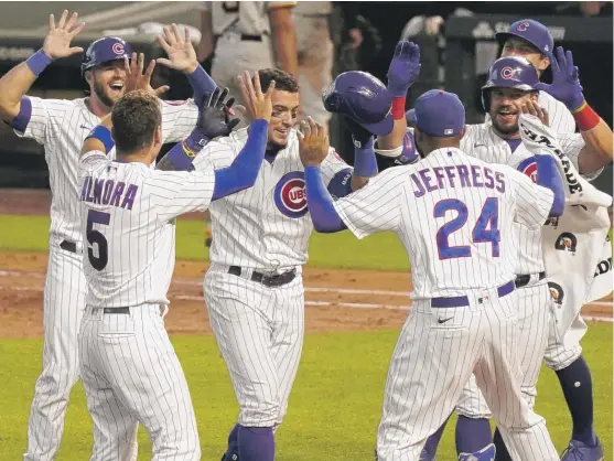  ?? GETTY IMAGES ?? Javy Baez (center) celebrates with teammates after his RBI single in the 11th inning gave the Cubs a 2-1 victory Sunday against the Pirates and a series sweep.