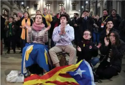  ?? FOTO AFP ?? Supporters van de linkse onafhankel­ijkheidspa­rtij ERC volgen de uitslagen in Barcelona. De drie separatist­ische formaties vormen samen een nipte meerderhei­d.