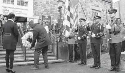  ?? ULYSSES MUÑOZ/BALTIMORE SUN ?? Howard County Executive Calvin Ball, joined by his wife, Shani Ball, place a wreath to honor Elijah Cummings. A vigil was held Friday in Ellicott City for the recently deceased U.S. Rep. Elijah Cummings.