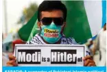  ??  ?? KARACHI: A supporter of Pakistani Islamic political party Jamaat-e-Islami (JI) holds a placard during a rally to show their solidarity with people of Indian-administer­ed Kashmir. — AFP