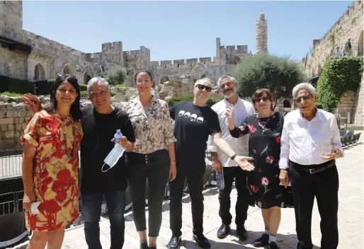  ?? (Ricky Rachman) (Yad Izhak Ben-Zvi Photograph­ic Archives) ?? AT THE Tower of David (left to right): Museum director Eilat Lieber; Gavri Banai; exhibition curator Tal Kobo; musical adviser Yoav Kutner; Evyatar Banai and his parents Simcha and Judge Yitzhak Banai.
Below: SIX OF the Banai siblings on the roof of their modest family home on Agas Street in the Jerusalem shuk, 1949.