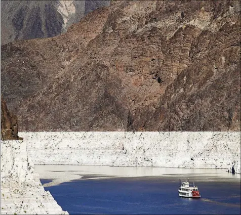  ?? JAE C. HONG / ASSOCIATED PRESS FILE (2015) ?? A riverboat glides through Lake Mead on the Colorado River at Hoover Dam near Boulder City. The bathtub ring indicates the high-water mark for the lake.