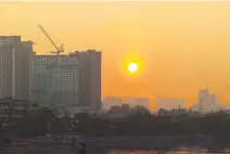  ?? PHILIPPINE STAR / MIGUEL DE GUZMAN ?? THE SUN rises behind buildings as seen from the Mabini Bridge in Manila, June 16, 2023.