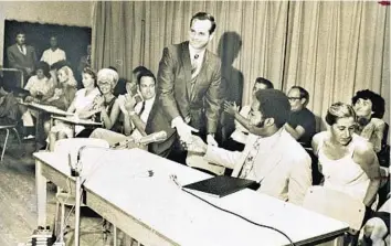  ?? SUN SENTINEL FILE PHOTOS ?? Ellis Rubin, standing, shakes hands with W. George Allen during a PTA meeting at McNab Elementary School.