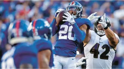  ?? ADAM HUNGER/AP ?? Giants safety Julian Love (20) intercepts a pass intended for Ravens fullback Patrick Ricard (42) in the fourth quarter Sunday in East Rutherford, New Jersey.