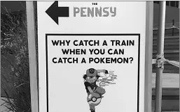  ?? Associated Press ?? A sign at The Pennsy food court is shown near New York's Penn Station, urging passersby to catch a Pokémon instead of a train.