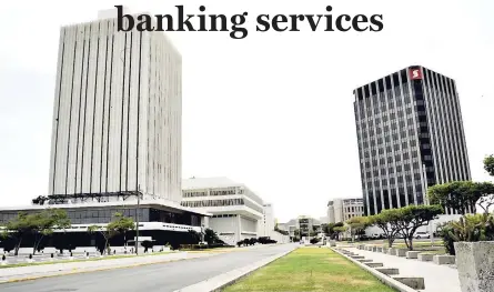  ??  ?? The Bank of Jamaica is seen at left, while Scotiabank Jamaica is to the right. The central bank says banks may now apply for permits for businesses to act as agents and provide banking services on their behalf.