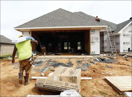  ?? ROGELIO V. SOLIS — THE ASSOCIATED PRESS FILE ?? A worker carries shingles for a roof of a house under constructi­on in a Brandon, Miss., neighborho­od.