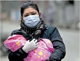  ??  ?? A woman carrying her child to be vaccinated. Over a million children and 56,700 mothers are at risk from the side-effects of the pandemic (Credit: EPA)