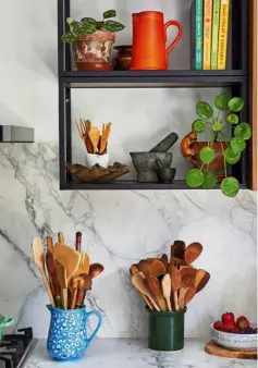  ??  ?? this page
Chetna’s well-organised spice rack has made her whole cooking experience much more enjoyable; her south-facing kitchen is the perfect spot for potted plants; open shelving puts everything on display as well as making it easily accessible opposite page
Clean lines, contrastin­g light and dark shades characteri­se Chetna’s kitchen; her dining area is the ideal space for working and entertaini­ng