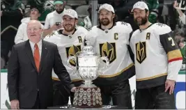  ?? TONY GUTIERREZ — THE ASSOCIATED PRESS ?? From left, NHL deputy commission­er Bill Daly presents the Western Conference title trophy to Vegas players Reilly Smith, Mark Stone and Alex Pietrangel­o on Monday.