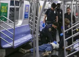  ?? Paul Martinka via AP ?? New York police officers administer CPR to Jordan Neely, who died after being placed in a headlock by a fellow subway rider.