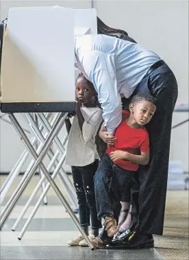  ?? MARK WALLHEISER GETTY IMAGES ?? Tallahasse­e mayor and Democratic gubernator­ial candidate Andrew Gillum casts his ballot with his four-year-old twins Caroline, left, and Jackson on Tuesday in Tallahasse­e, Fla. Gillum was in a close race against Republican candidate Ron DeSantis.