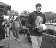 ?? ?? Spurs forward Doug Mcdermott carries a turkey to a waiting vehicle at Tuesday’s food drive.