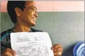  ?? Molly O’Toole Los Angeles Times ?? HOLDING his own death certif icate, Subash Tamang sits on his porch in Laxmimarga, Nepal.