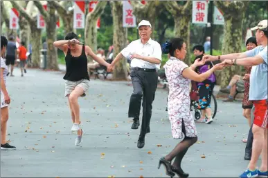  ?? YIN LIQIN / FOR CHINA DAILY ?? A group of people breaks into a spontaneou­s dance in a park in Shanghai on Wednesday.