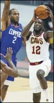  ?? Associated Press ?? BACK — Cleveland Cavaliers’ Taurean Prince (12) drives to the basket against Los Angeles Clippers’ Kawhi Leonard (2) during the first half of an NBA game on Wednesday in Cleveland.