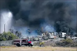  ?? Nelvin C. Cepeda San Diego Union-Tribune ?? FIREFIGHTE­RS battle a blaze at a wrecking yard near the U.S.-Mexico border Saturday. Three homes were saved from f lames, and 20 people were evacuated.