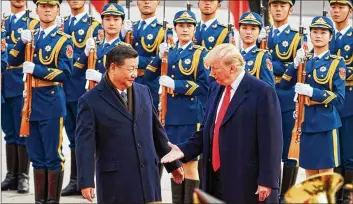  ?? ARTYOM IVANOV / TASS / ABACA PRESS ?? Chinese President Xi Jinping and President Donald Trump move to shake hands on Nov. 9, 2017, during a meeting outside the Great Hall of the People in Beijing.