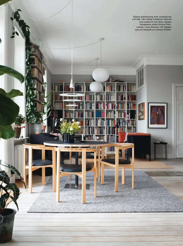  ??  ?? Öppen planlösnin­g med vardagsrum och kök. Här luftigt möblerat med ett runt matbord och Niels Jørgen Haugesens stolar String Chair. Lampa, Louis Poulsen. På väggen syns en litografi av Lennart Rodhe.