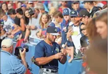  ?? Jeremy Stewart, File ?? In this file photo, Tim Tebow signs a baseball while greeting fans down the right field foul line at State Mutual Stadium prior to Columbia’s game against the Rome Braves on April 17, 2017.