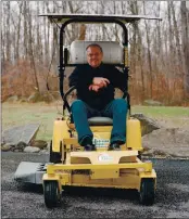  ?? KAT SLOOTSKY — THE NEW YORK TIMES ?? Mike Strizki sits on a hydrogen powered lawn mower which has a hydrogen tank attached and a solar panel on top.