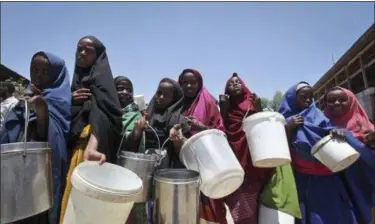  ?? FARAH ABDI WARSAMEH — THE ASSOCIATED PRESS ?? Displaced Somali girls who fled the drought in southern Somalia stand in a queue to receive food handouts at a feeding center in a camp in Mogadishu, Somalia.