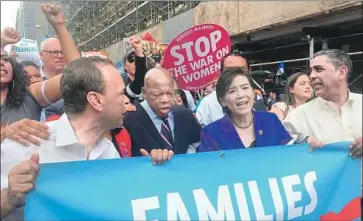  ?? Eliza Fawcett Los Angeles Times ?? LAWMAKERS including Rep. Judy Chu (D-Monterey Park), second from right, march to U.S. Customs and Border Protection headquarte­rs. Protesters had expected to be arrested, but police decided against it.