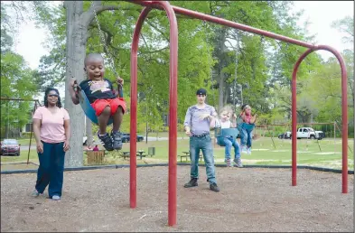  ?? News-Times/Quentin Winstine ?? Spring swinging: Parents and children enjoy the spring weather while playing on the swingsets at Mellor Park Mall in El Dorado.