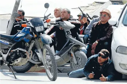  ?? Photos: REUTERS ?? Police officers take up positions outside parliament in Tunis during the attack by gunmen.