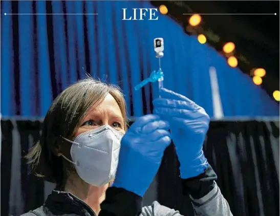  ?? JOSE M. OSORIO/CHICAGO TRIBUNE ?? Corinne Puchalla, a pharmacist with the University of Illinois at Chicago College of Pharmacy, prepares a Pfizer COVID-19 vaccine dose that will be given to patients at Credit Union 1 Arena in Chicago on Feb. 8.