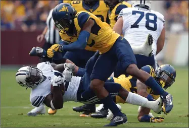  ?? APPHOTO ?? BYU running back Jamaal Williams, bottom, is knocked down by West Virginia safety Jeremy Tyler (2).