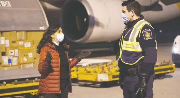  ?? THE CANADIAN PRESS / CANADIAN ARMED FORCES-CPL MATTHEW TOWER / FILES ?? Procuremen­t Minister Anita Anand oversees the off-loading of COVID-19 vaccines with members of Canadian Border Services Agency in Montreal in December.