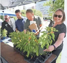  ??  ?? Lisa Ridgely (right) and Kevin Moser (second from right) win ornamental pepper plants in the Milwaukee Department of Public Works trivia game during the 12th Annual Downtown Employee Appreciati­on Week.