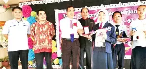  ??  ?? FAIMIN menyampaik­an anugerah kepada Tokoh Murid perempuan, Iqkah Syafirah Sabry.