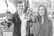  ??  ?? USC students Jordan Adishian, 21, from Corona, Calif., and Julia McCaffrey, 21, from Ridgefield, Conn., take photos of each other on campus. Neither are keen on investing in Snapchat. Says Adishian, “Wait it out a little bit.”