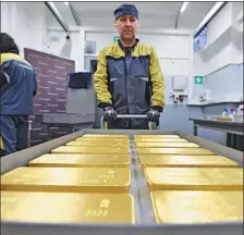  ?? REUTERS ?? Marked ingots of 99.99 percent pure gold are placed in a cart at the Krastsvetm­et nonferrous metals plant in the Siberian city of Krasnoyars­k, Russia.