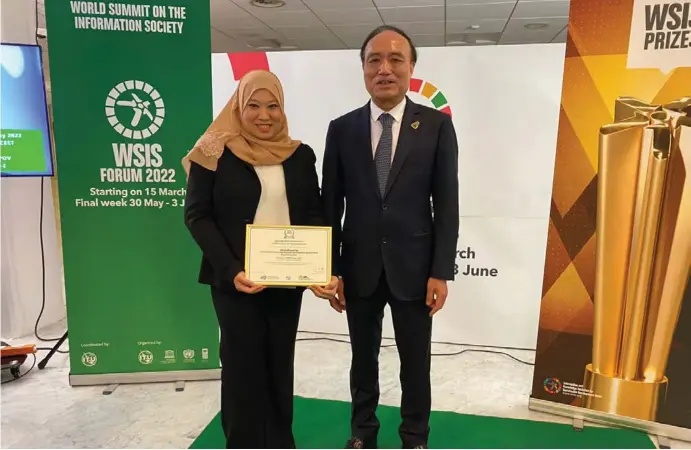  ?? ?? Mr. Houlin Zhao (R) presenting the Award Certificat­e to YM Dk Nooraslena binti Pengiran Dato Paduka Haji Sallehudin (L). Image courtesy of AITI