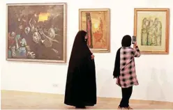  ?? — AFP photos ?? Visitors look at paintings by renowned artist Fayiq Hassan on display at Iraq’s Ministry of Culture in Baghdad.