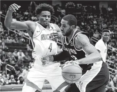  ?? Melissa Phillip / Staff photograph­er ?? Rockets forward Danuel House Jr. (4), who took Eric Gordon’s place in the starting lineup Wednesday night, tries to stay in front of the Spurs’ LaMarcus Aldridge.