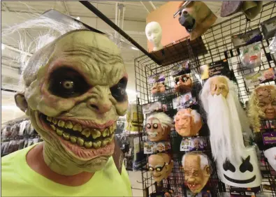  ?? (NWA Democrat-Gazette/Flip Putthoff) ?? David Henderson, a manager at Halloween Express at Frisco Station Mall in Rogers, wears a scary mask inside the store on Wednesday. Go to nwaonline.com/211010Dail­y/ to see more photos.