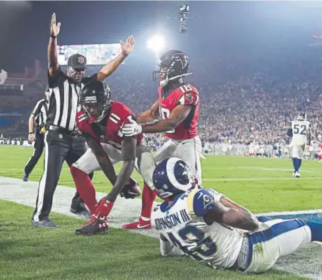  ?? Harry How, Getty Images ?? Atlanta Falcons wide receiver Julio Jones (11) finishes his touchdown catch against Los Angeles Rams safety John Johnson III as the Falcons’ Taylor Gabriel watches during the fourth quarter at the L.A. Coliseum on Saturday night.