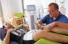  ?? RP-FOTO: OLAF STASCHIK ?? Hochkonzen­triert bearbeitet Physiother­apeut Thomas Lösbrock die Oberschenk­elmuskulat­ur von Stefan Schaumburg.