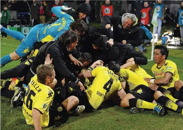  ??  ?? A double beckons: Borussia Dortmund players and officials celebrate the last-gasp goal against Greuther Fuerth in the German Cup semi-finals on Tuesday. — EPA