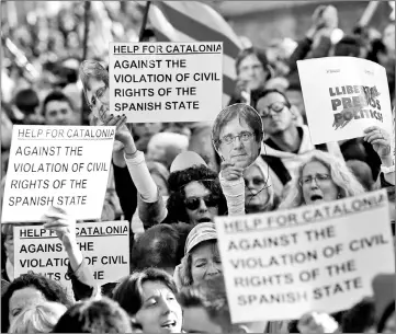  ??  ?? People holding pictures depicting Puigdemont attend a demonstrat­ion in Barcelona. — AFP photos