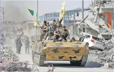  ?? Picture: REUTERS ?? VICTORY: Syrian Democratic Forces celebrate their triumph in Raqqa atop a tank