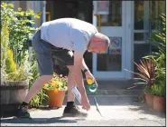  ?? (AP/Jon Super) ?? David Waugh sprays safe distance markers on the ground Wednesday at Lostock Hall Primary school in Poynton near Manchester, England.